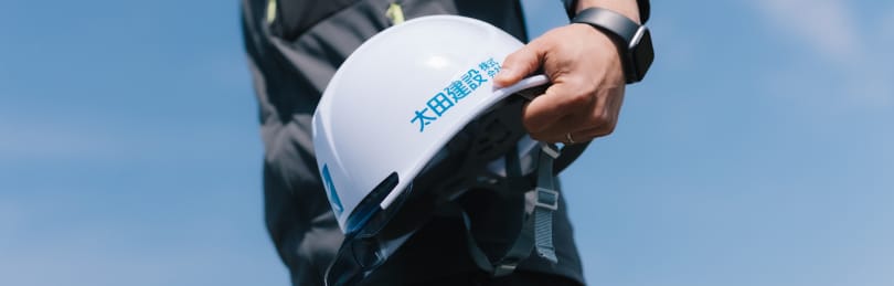 太田建設のヘルメットを持つ男性